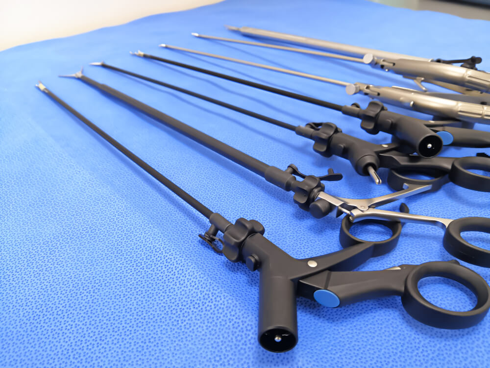 Narzędzia do laparoskopii leżące na stole, na niebieskim materiale.