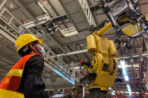 Robot podnoszący auto w fabryce motoryzacyjnej.