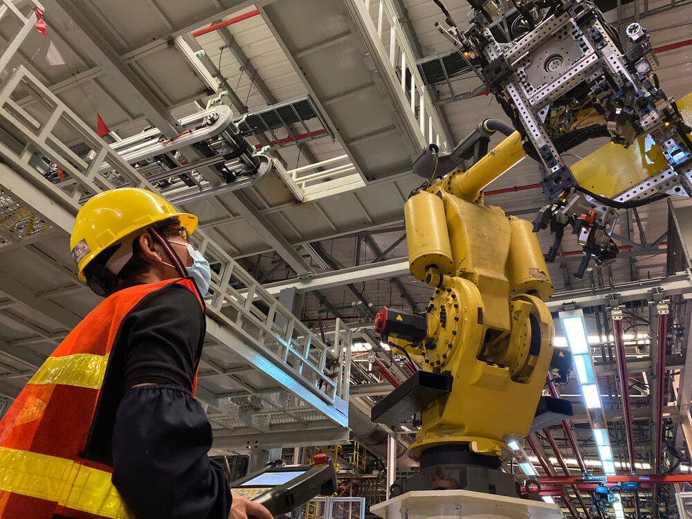 Robot podnoszący auto w fabryce motoryzacyjnej.